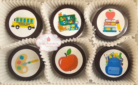 A set of chocolate covered oreos with various edible images including a bus, apple, pencil, and backpack.