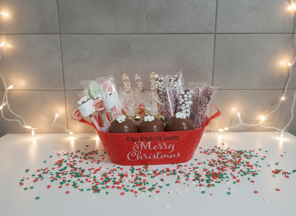Red 'Merry Christmas' basket with chocolate treats and candy on a light background