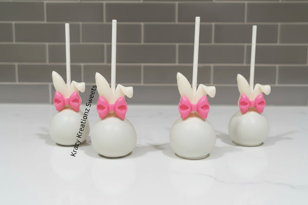 White rabbit-shaped treats with pink bows on a white surface, branded 'Krazy Kreationz Sweets'.